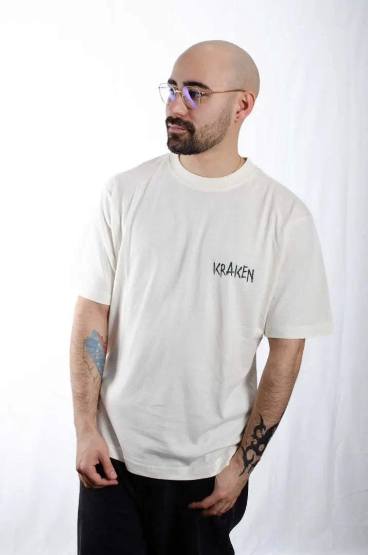 Modelo hombre vistiendo la Camiseta El orgullo de tu Papá. Camiseta streetwear oversized color Leche de coco, fabricada con algodón 100% orgánico.
