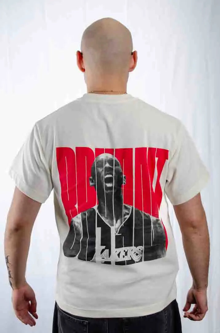 Vista trasera de un modelo hombre vistiendo la Camiseta Kobe Bryant. Camiseta streetwear oversized con hombros caídos, de algodón 100% orgánico en color Leche de coco.