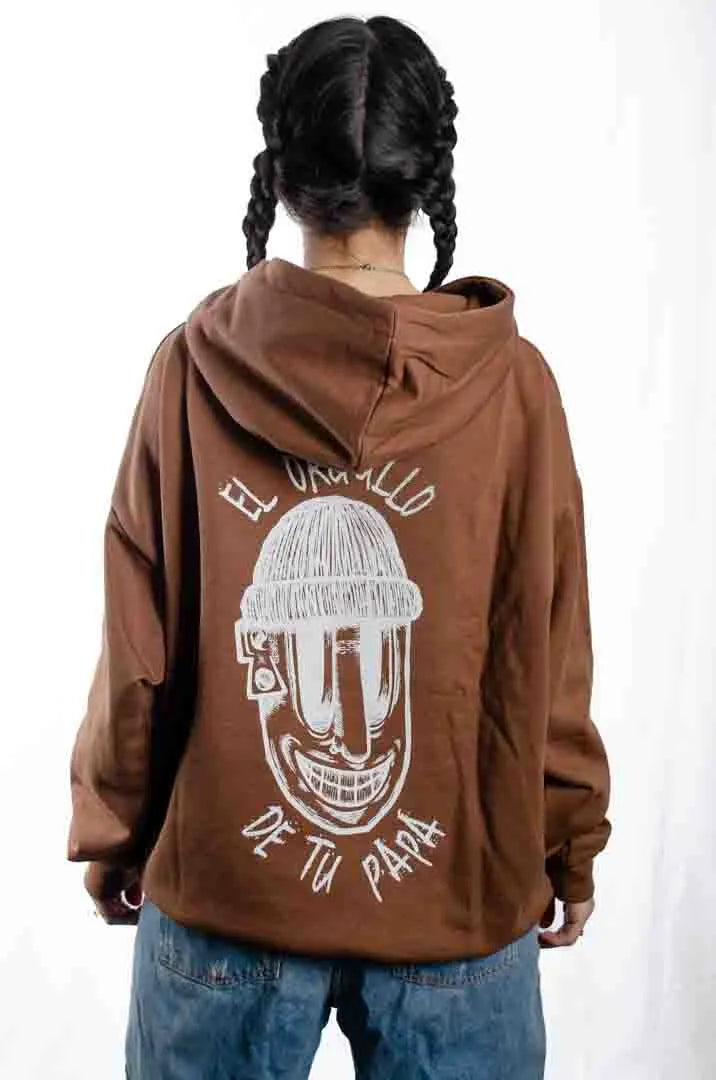 Vista trasera de una modelo mujer vistiendo la Sudadera El Orgullo de tu Papá. Sudadera streetwear oversized con capucha, en color Brownie especial y fabricada con material de felpa perchada 100% algodón.
