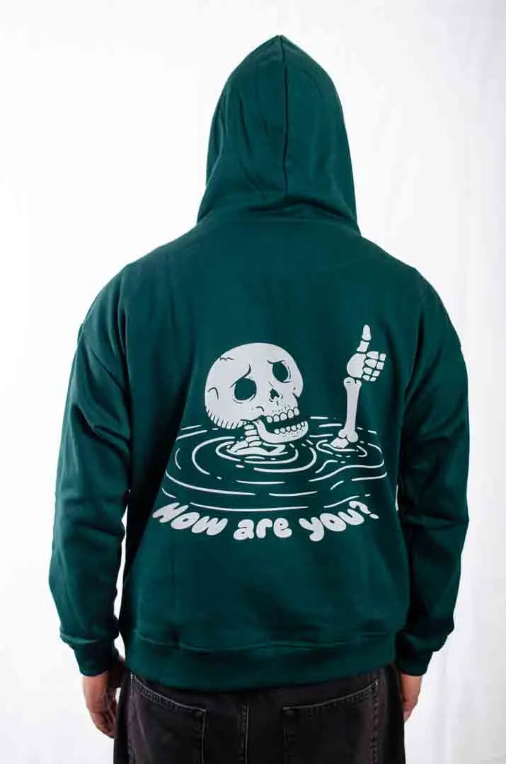 Vista del gráfico en la espalda de la Sudadera Keloke con capucha puesta. Sudadera streetwear oversized, en color verde solera y fabricada con material de felpa perchada 100% algodón.