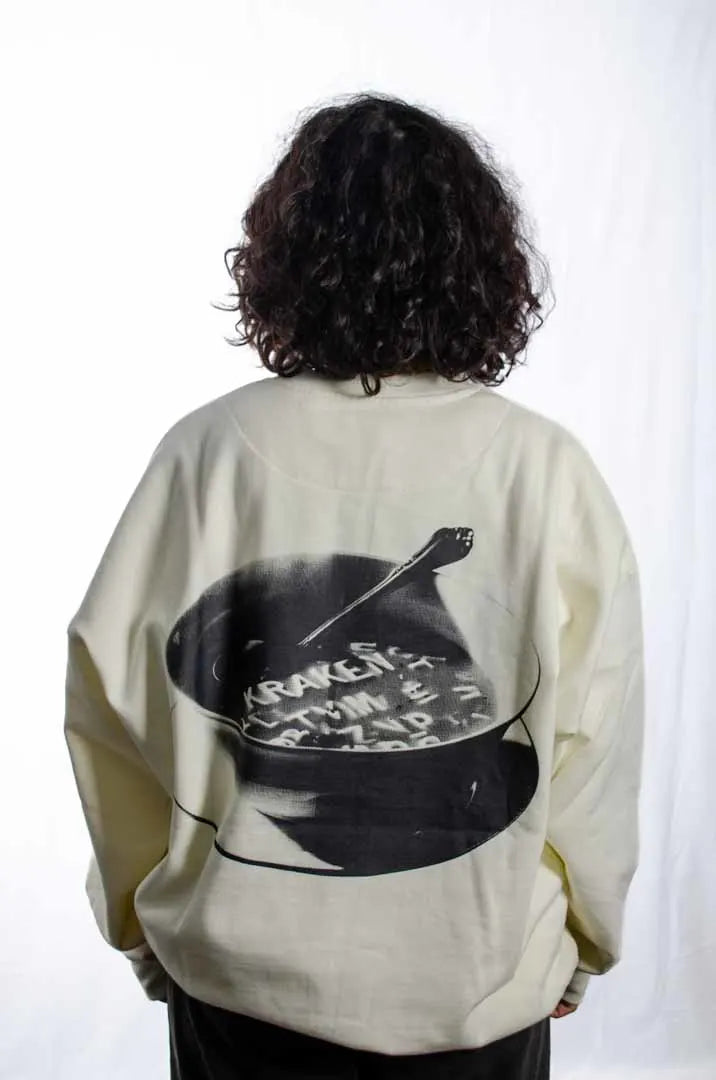 Vista trasera de una modelo mujer vistiendo la Sudadera Sancocho. Sudadera brushed oversized sin capucha, de felpa perchada 100% algodón en color Leche de coco."