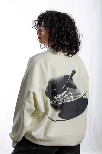 Vista lateral de una modelo mujer vistiendo la Sudadera Sancocho. Sudadera brushed oversized sin capucha, de felpa perchada 100% algodón en color Leche de coco.