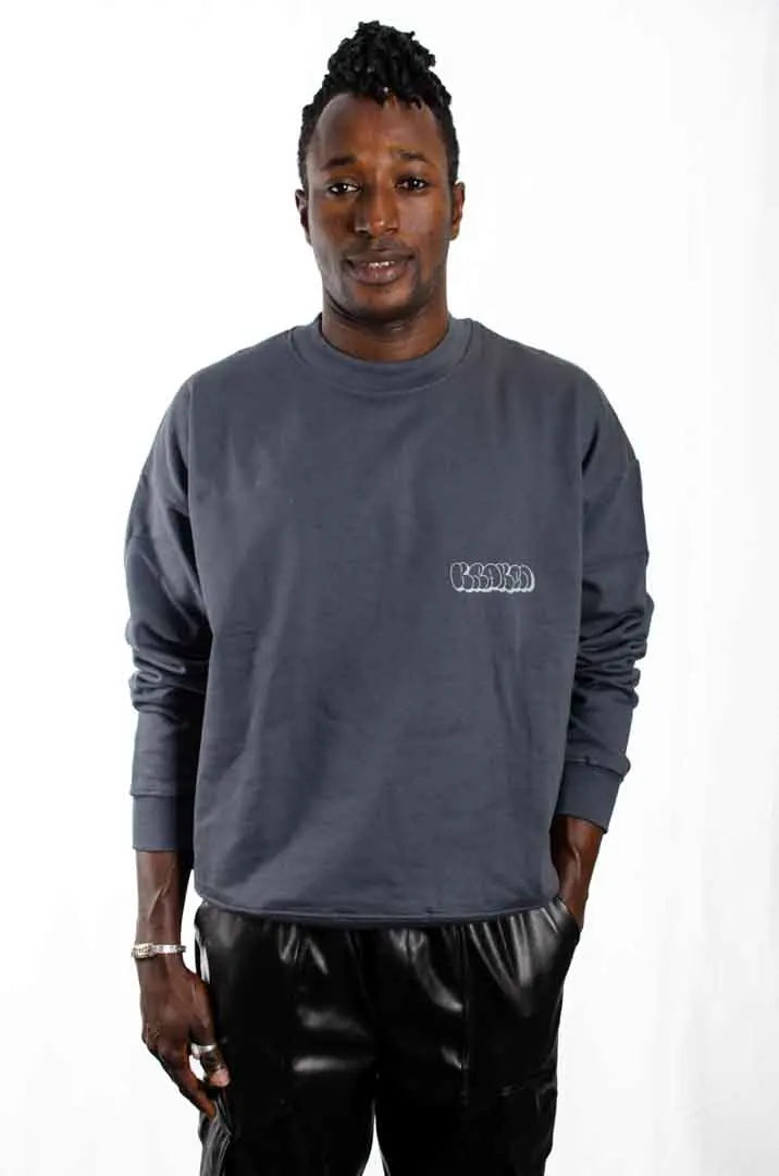 Modelo hombre vistiendo la Sudadera La Brujas. Sudadera streetwear oversized sin capucha, de felpa perchada 100% algodón en color Gris Lobo.