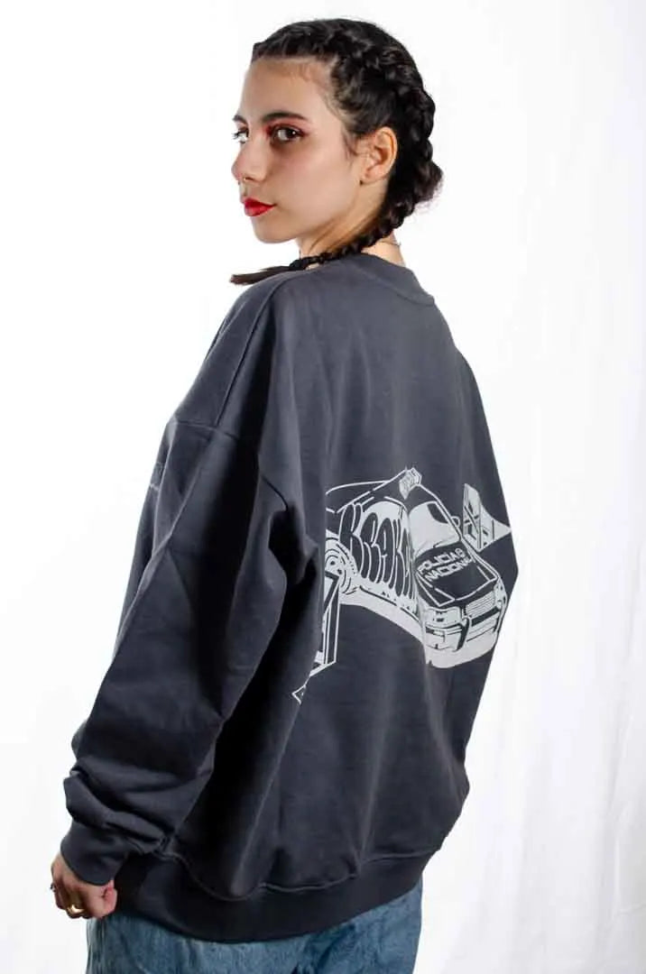 Vista lateral de una modelo mujer vistiendo la Sudadera La Brujas. Sudadera streetwear oversized sin capucha, de felpa perchada 100% algodón en color Gris Lobo.