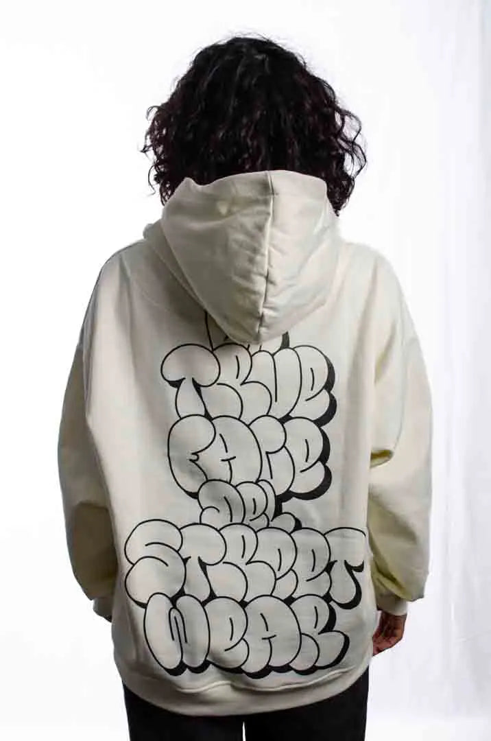 Vista trasera de una modelo mujer vistiendo la Sudadera La True Face. Sudadera hoodie oversized con capucha, 100% algodón felpa en color Leche de coco.