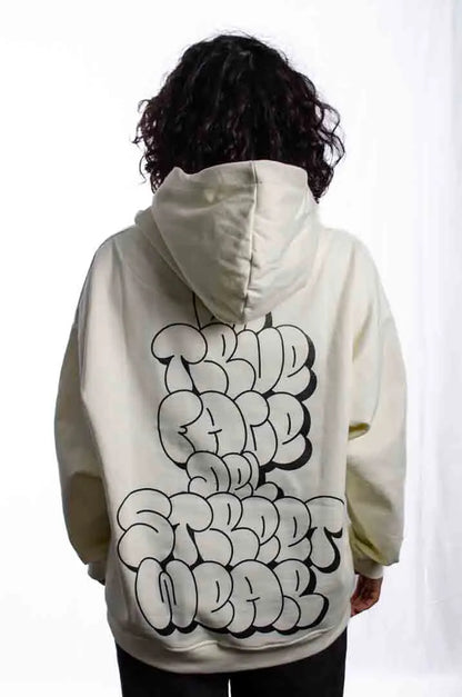 Vista trasera de una modelo mujer vistiendo la Sudadera La True Face. Sudadera hoodie oversized con capucha, 100% algodón felpa en color Leche de coco.