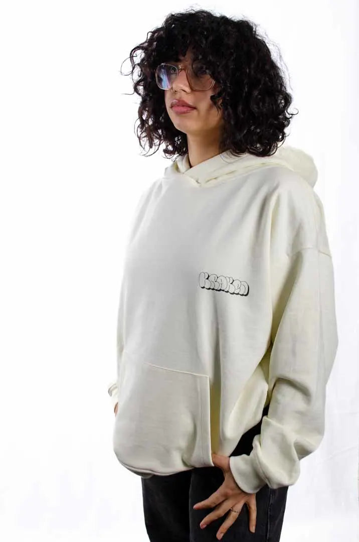 Modelo mujer vistiendo la Sudadera La True Face. Sudadera hoodie oversized con capucha, 100% algodón felpa en color Leche de coco.