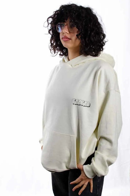 Modelo mujer vistiendo la Sudadera La True Face. Sudadera hoodie oversized con capucha, 100% algodón felpa en color Leche de coco.