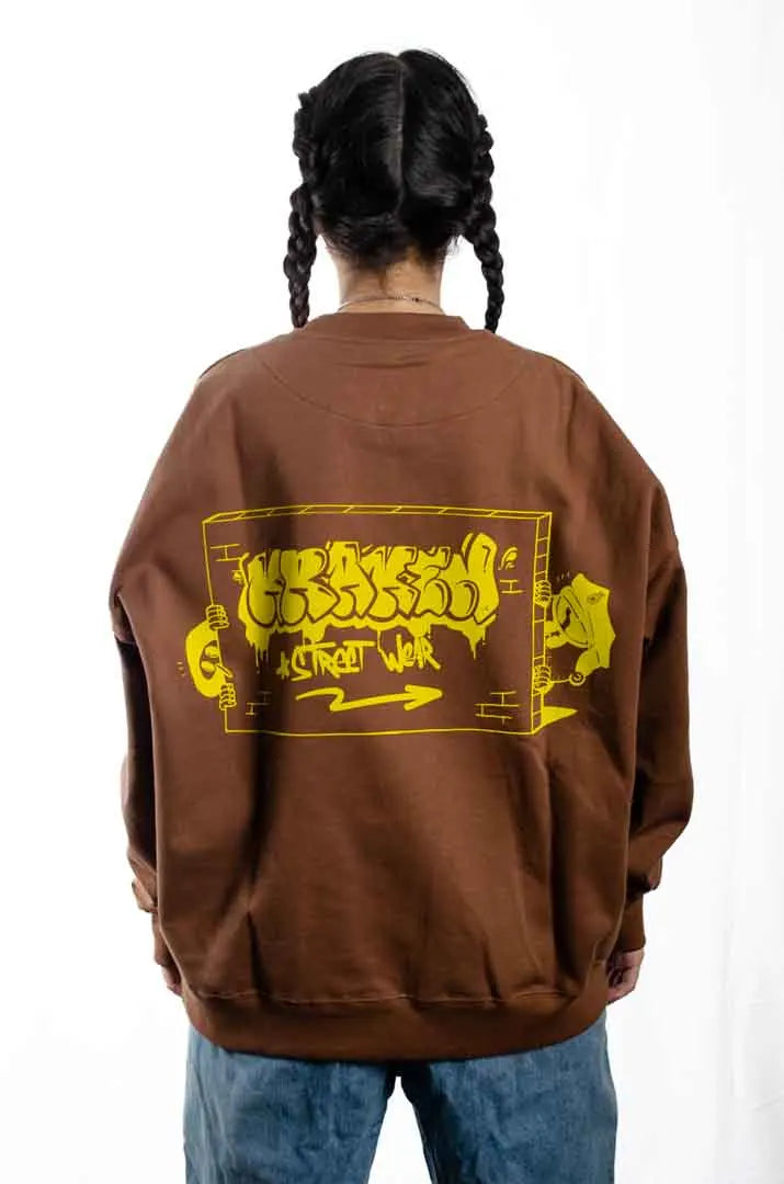Vista trasera de una modelo mujer vistiendo la Sudadera Tu Tío Paco. Sudadera brushed oversized sin capucha, de felpa perchada 100% algodón en color Brownie especial.