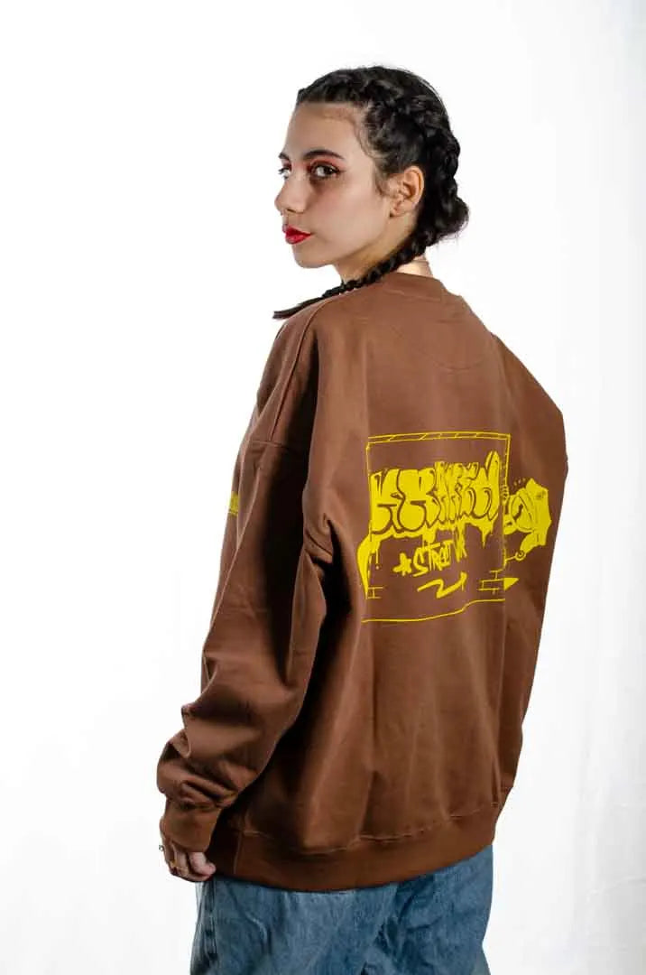 Vista lateral de una modelo mujer vistiendo la Sudadera Tu Tío Paco. Sudadera brushed oversized sin capucha, de felpa perchada 100% algodón en color Brownie especial.